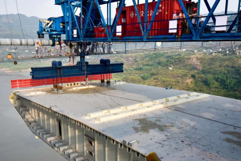 Workers connect the first steel box girder with cables at the construction site of the Fuma Yangtze River Bridge in Wanzhou, Chongqing, in August. Photo: Xinhua