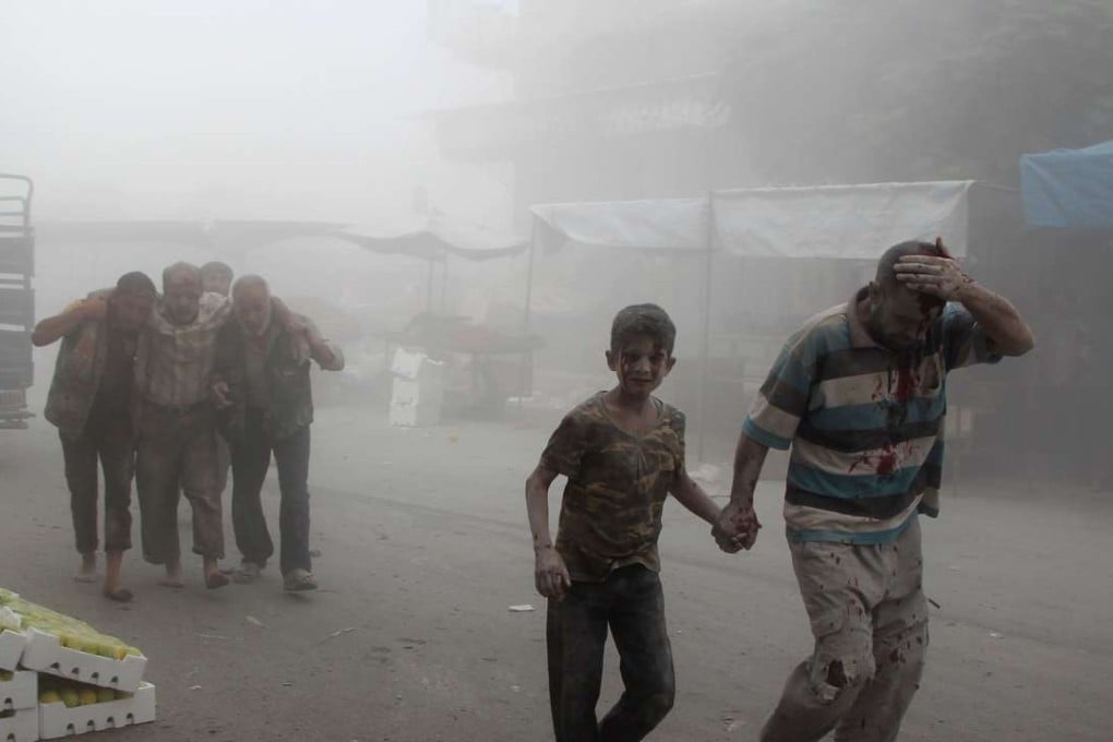 A wounded man and a child walk away as others help a victim at the scene of a reported air strike on the rebel-held northwestern city of Idlib on Saturday. Photo: AFP