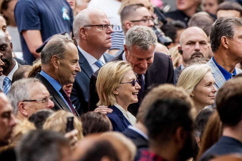 Democratic presidential candidate Hillary Clinton, centre, accompanied by Sen ator Chuck Schumer (left) and Representative Joseph Crowley (second from left) speaks with New York Mayor Bill de Blasio (centre right), during a ceremony at the September 11 memorial, in New York, on Sunday. Clinton left the event feeling ill. Photo: AP