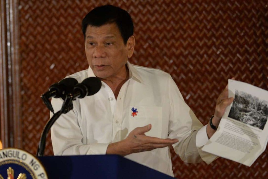 Philippine President Rodrigo Duterte holds up a photo and cites accounts of US troops who killed Muslims during the US’ occupation of the Philippines in the early-1900s, during a speech at the Malacanang palace in Manila. Photo: AFP