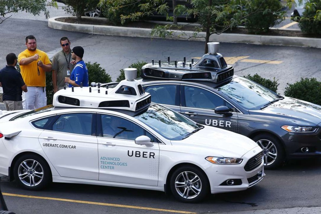 Uber employees stand by self-driving Ford Fusion hybrid cars while test driving the vehicles in Pittsburgh last month. Photo: AP