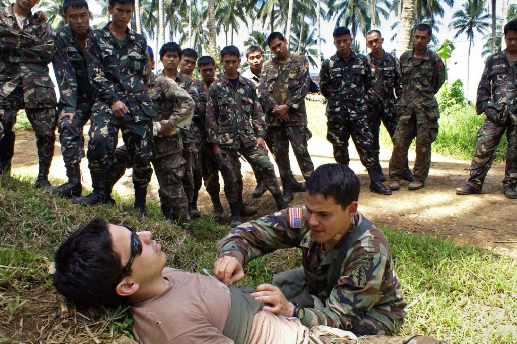 Two US Army Special Forces members conduct tactical combat casualty care training for Philippine Army soldiers (background) in Mindanao. File photo: AFP