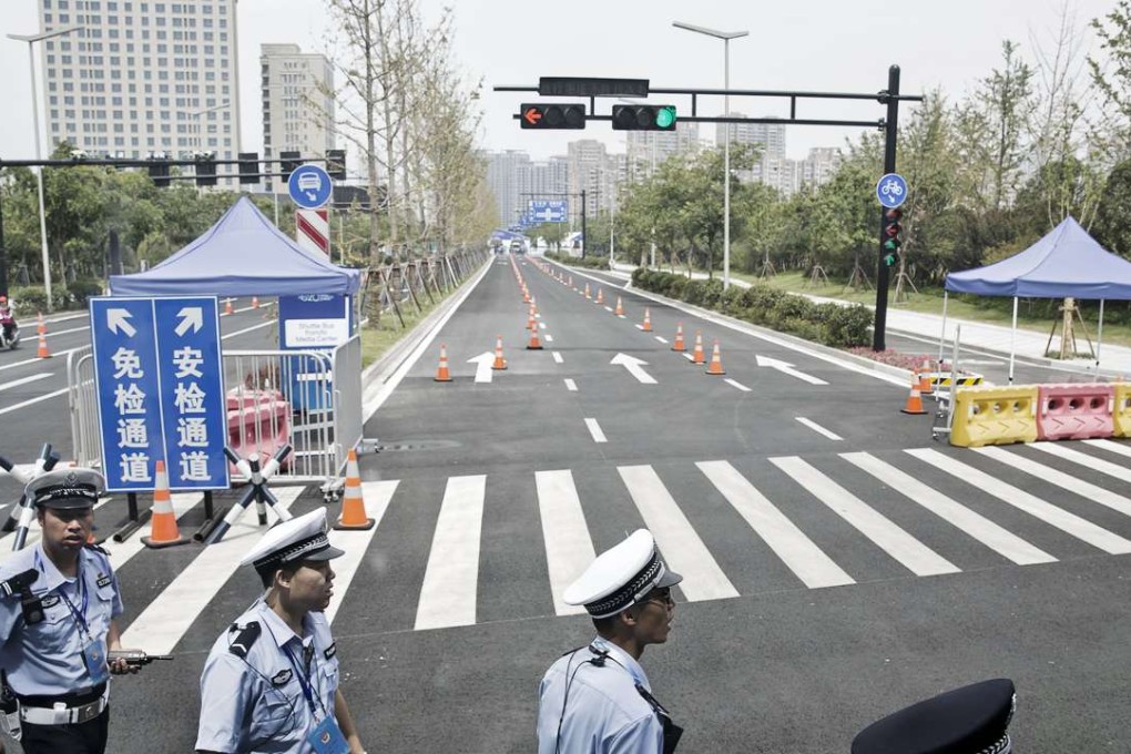 Police officers walk past a roadblock leading to a venue for the Group of 20 (G-20) summit in Hangzhou, China. Group of 20 leaders meeting in Hangzhou this weekend will encounter a manicured, booming city transformed by billions of dollars in infrastructure investment that includes underground tunnels, new subway lines and a six-lane highway. Photo: Bloomberg