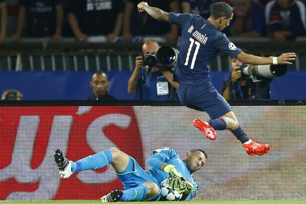 PSG's Angel di Maria leaps over Arsenal goalkeeper David Ospina at the Parc des Princes. Photo: AP