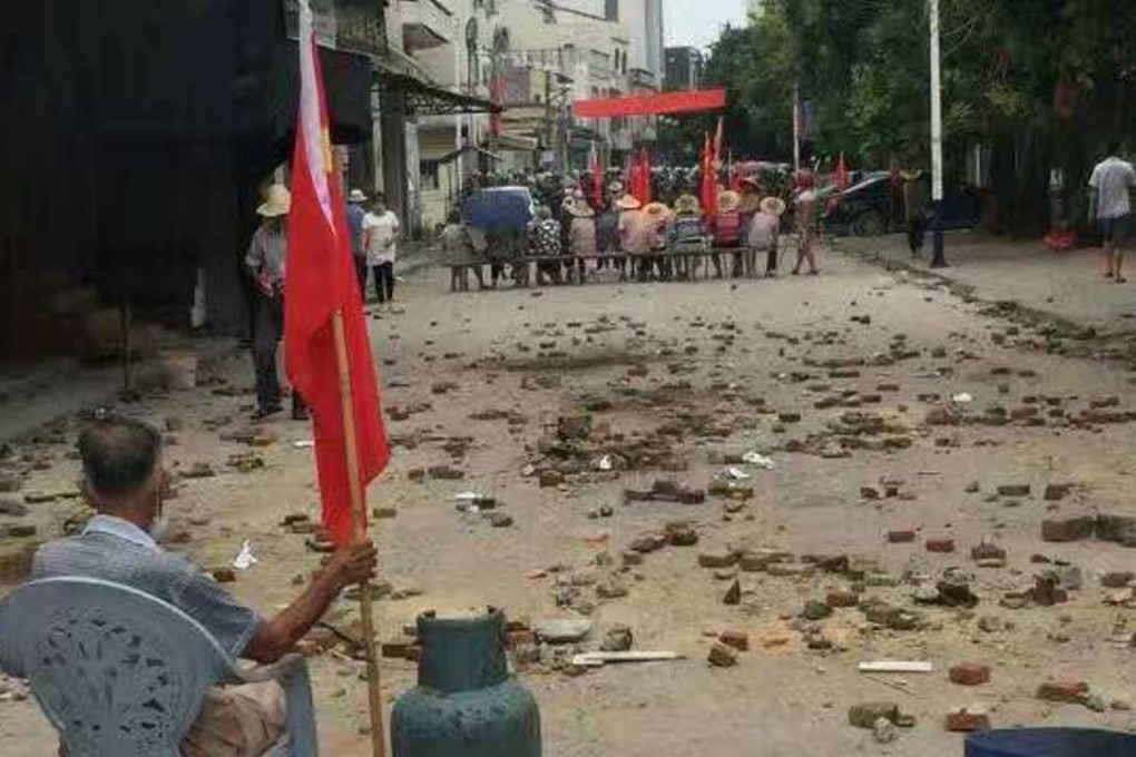 Protesters sit in the road in the village Wukan after clashes with police early on Tuesday morning. Photo: SCMP Pictures