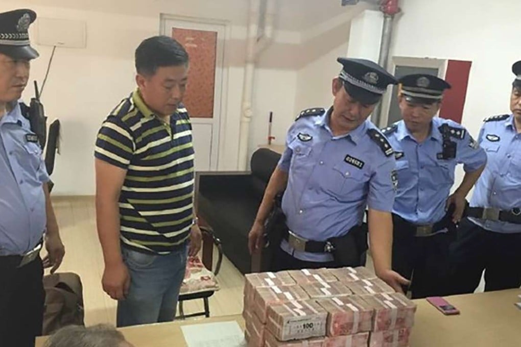 Police officers guard the 5 million yuan as the director of the neighbourhood prepares to distribute it to residents. Photo: SCMP Pictures