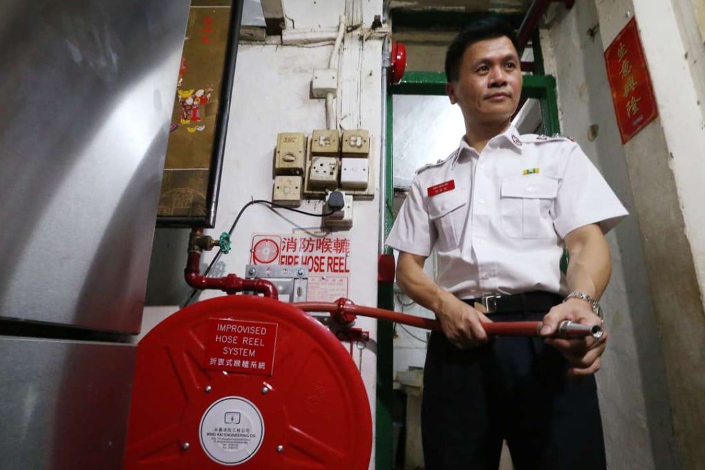 Fire Services Department senior division officer Chiu Wai-kin with the improvised hose reel system. Photo: K. Y. Cheng