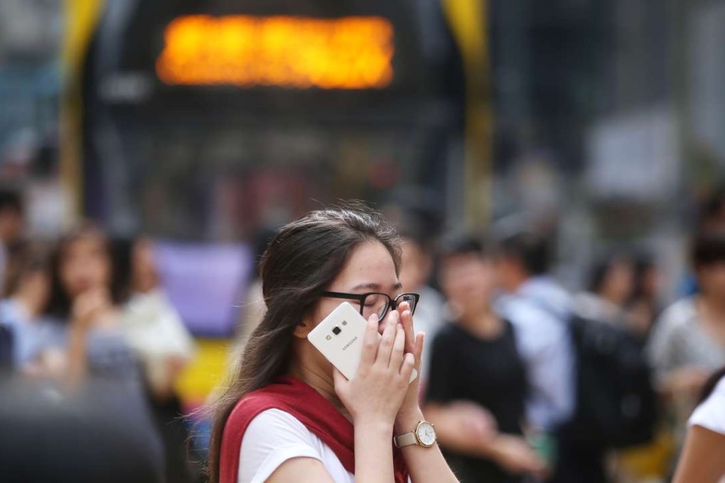 A woman covers her mouth at a crossing in Causeway Bay. Photo: Sam Tsang