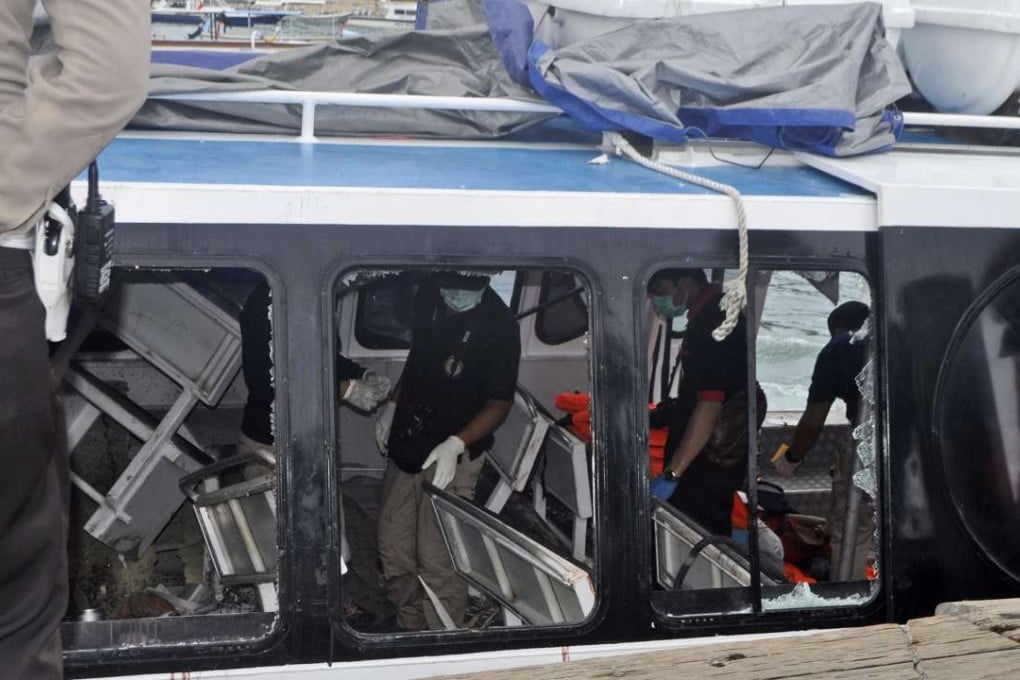 Police investigators examine the Gili Cat 2 boat after an explosion while it was enroute to nearby island of Lombok. Photo: AP