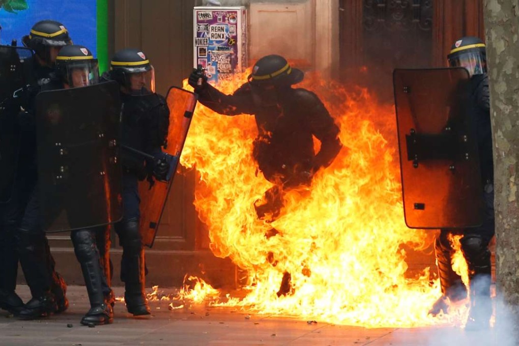 A French riot police officer is engolfed in flames from a Molotov cocktail thrown by protesters in Paris on Thursday. Photo: AFP