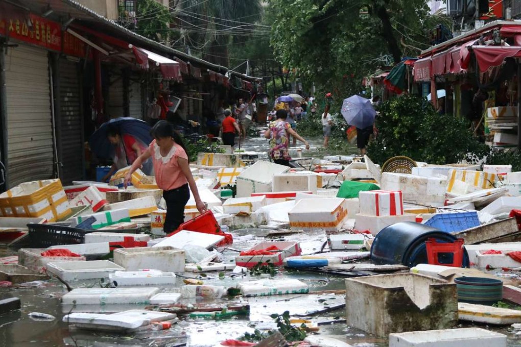 Residents clean up a flooded street in Xiamen, Fujian province. Photo: AFP