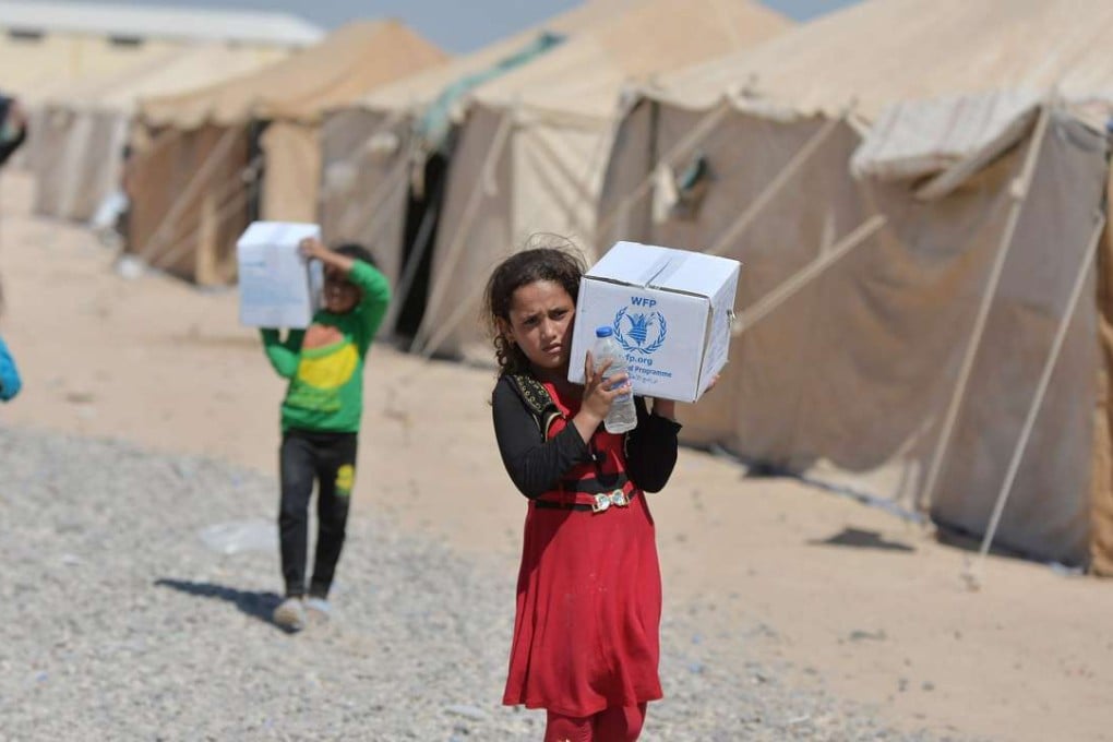 Iraqi displaced people from Syria receive aid supplies at a refugee camp in Baiji, north of Baghdad. Photo: Reuters