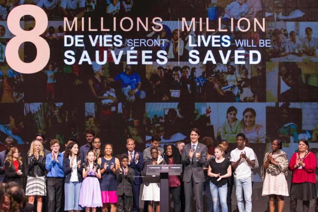 Canadian Prime Minister Justin Trudeau with young people after announcing that the Global Fund’s goal to raise enough money to save eight million more lives. Photo: AFP