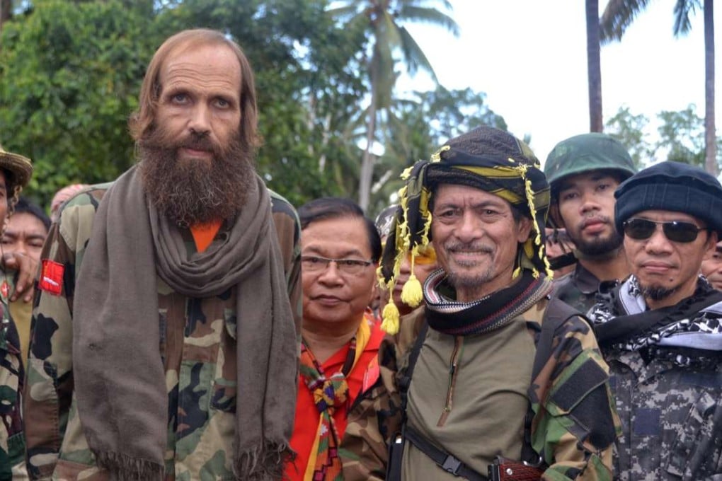 Released Norwegian hostage Kjartan Sekkingstad, front row left, poses with Moro National Liberation Front Chairman Nur Misuari, front row second right, after being turned over by ransom-seeking Abu Sayyaf extremists in Indanan township on Jolo island in southern Philippines. Photo: AP