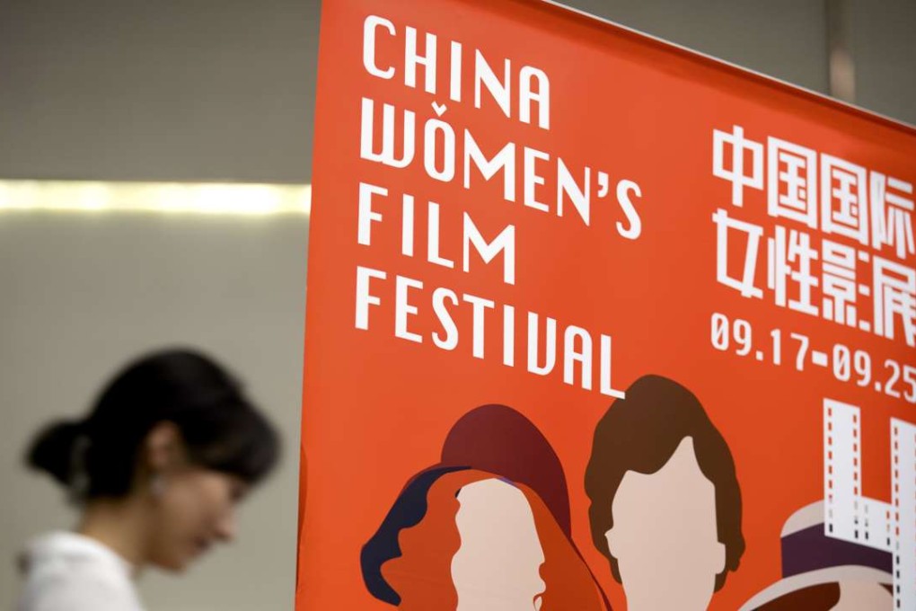 A participant walks past a banner for the China Women's Film Festival during its opening ceremony in Beijing. The festival runs until Sunday. Photo: AP