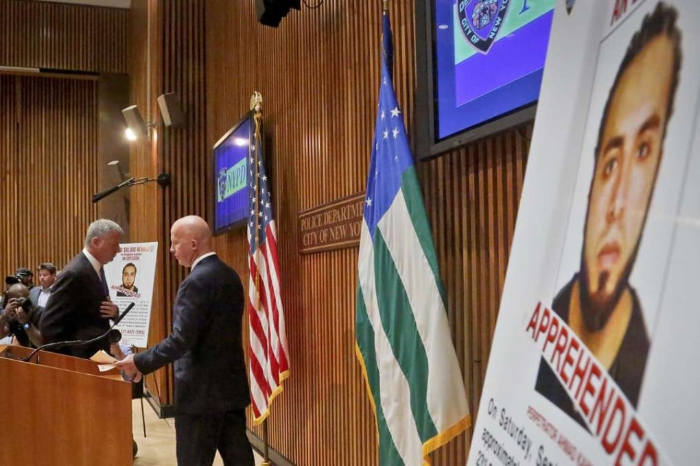 Mayor Bill de Blasio, left, and New York Police Department Commissioner James O'Neill arrive for a news conference to announce the arrest of bombing suspect Ahmad Kahn Rahami, shown on a display on Monday. Photo: AP
