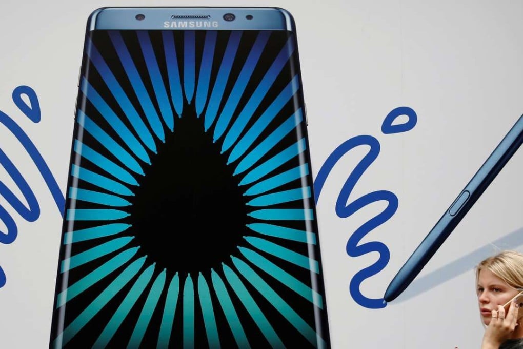 A woman speaks on an Apple phone as she passes an advert for the Samsung Galaxy Note 7 in London. Photo: Reuters