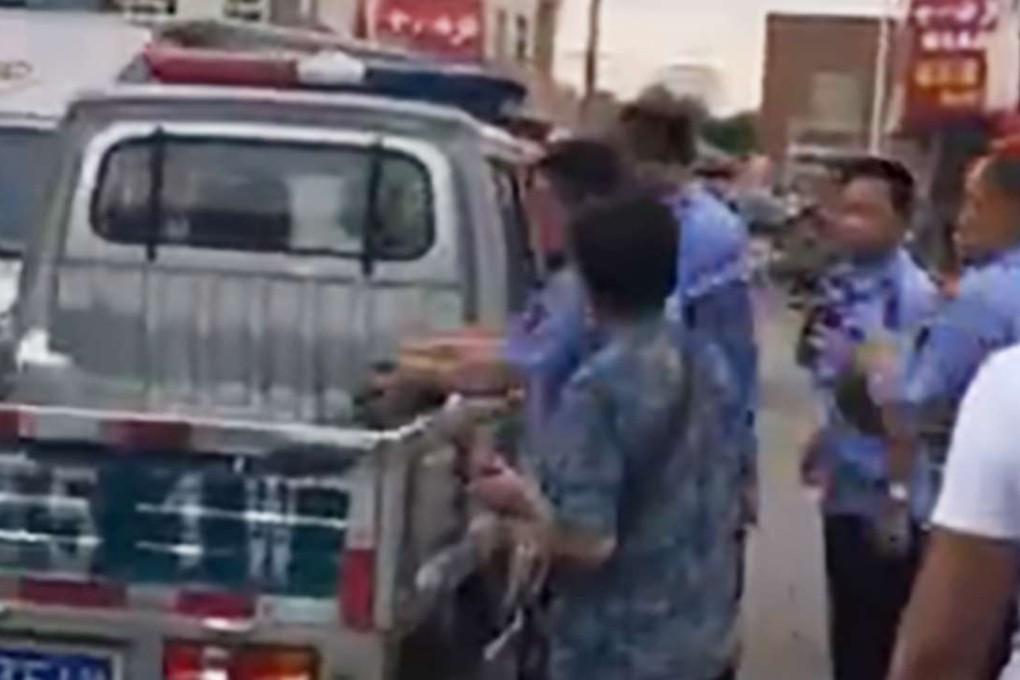 Urban enforcement officers are shown putting watermelons in their vehicle. Photo: SCMP Pictures