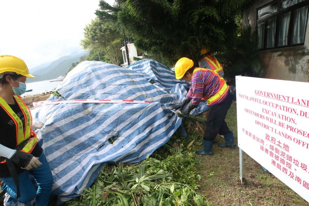 Staff from Lands Department erect a warning sign at the illegally developed land in Tung Ah Pui Village in Shek O. Photo: David Wong