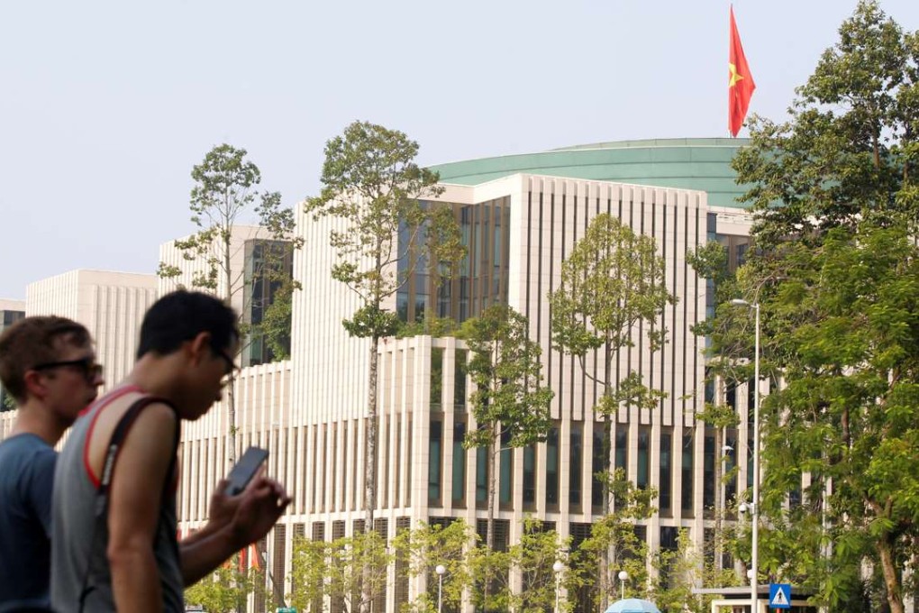 Tourists walk past Vietnam's National Assembly (Parliament) building in Hanoi, Vietnam. Photo: Reuters