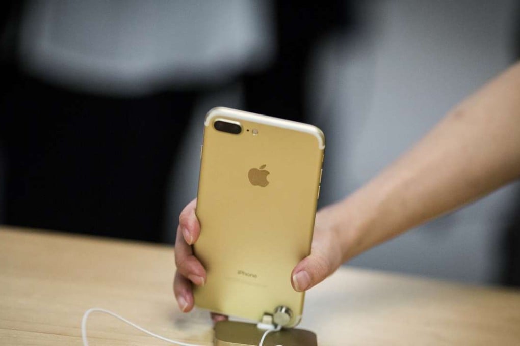 An employee picks up an iPhone 7 Plus smartphone at an Apple store in New York. Photo: Bloomberg