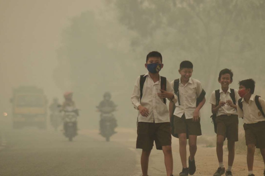 Students walk along a street as they are released from school to return home earlier due to the haze in Jambi, Indonesia's Jambi province on September 29. Photo: Reuters