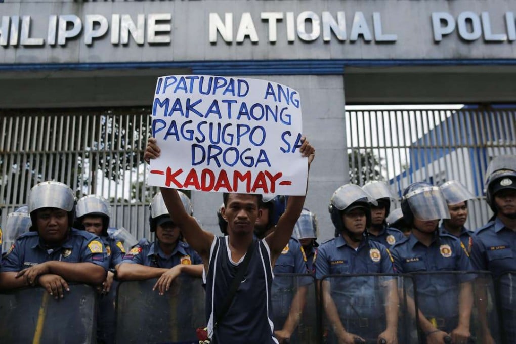 A Filipino human rights advocate holds a placard as he joins a demonstration in front of the Philippine National Police (PNP) headquarters, protesting the alarming number of deaths related to government's war against illegal drugs, in Quezon city, east of Manila. Photo: EPA