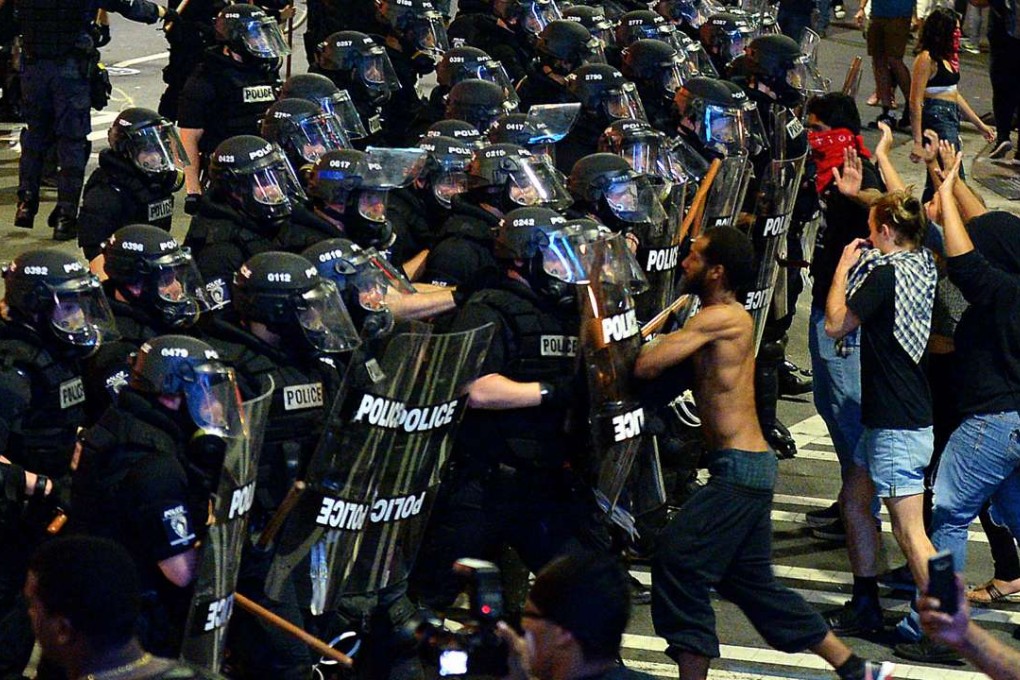 Charlotte-Mecklenburg police officers begin to move protesters down a street in Charlotte. Photo: AP