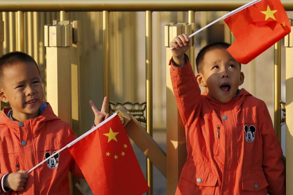 Twin boys hold China's national flags on the Tiananmen Gate in Beijing. Photo: Reuters