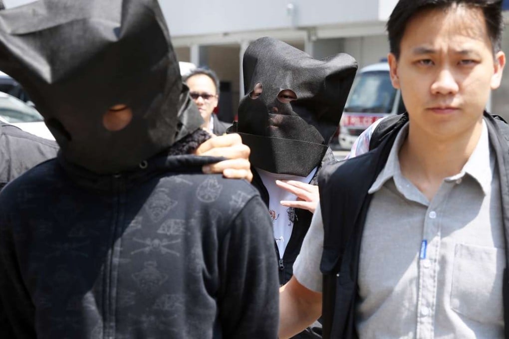 Suspects arrested for tailing legislator-elect Eddie Chu Hoi-dick being escorted by police. Photo: Sam Tsang