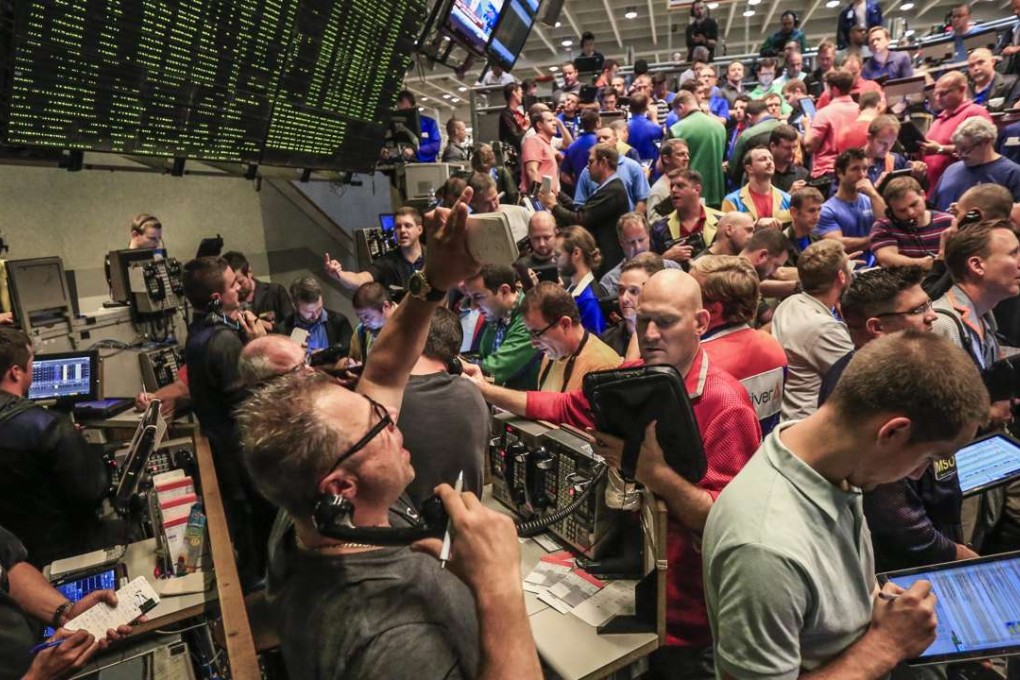 Traders working in the S&P options pit at the Chicago Board Options Exchange signal transactions in the wake of the Federal Open Markets Committee's decision not to raise interest rates following a two day meeting. Photo: EPA