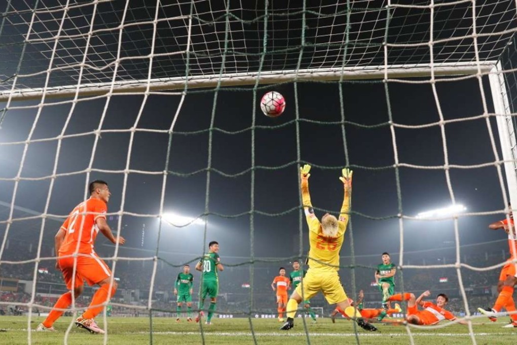 Beijing Guoan’s Yu Dabao slams the ball home to level the score during Shandong Luneng’s 2-1 win over Guoan on Sunday.