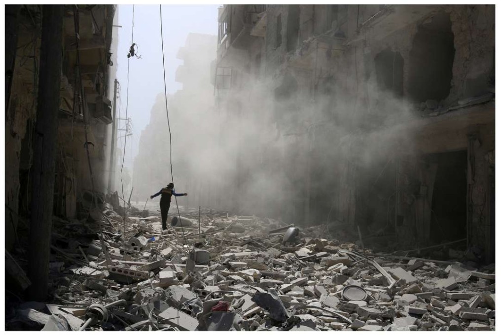 A man walks through rubble of damaged buildings after an airstrike on the rebel held al-Qaterji neighbourhood of Aleppo, Syria, on Sunday. Photo: Reuters