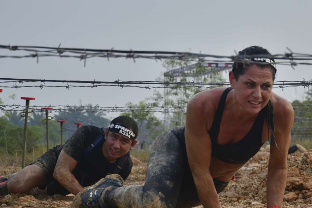 Nataile Dau, 44, crawling under barbed wire at Spartan Race Malaysia. She eventually finished third.
