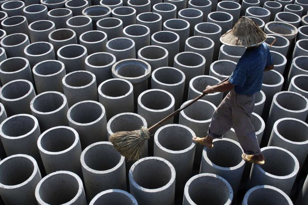 A worker walks over newly-made concrete pipes at a cement plant in Yingtan, Jiangxi province. Photo: Reuters