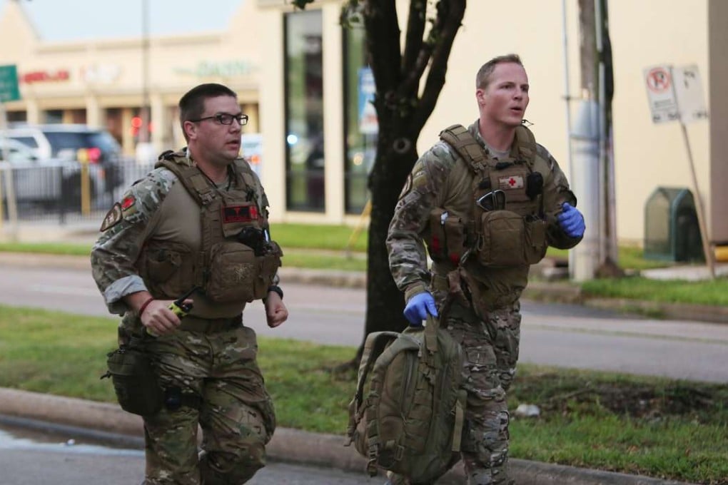Law enforcement officers run toward the scene of a shooting along Wesleyan at Law Street in Houston that left a number of people injured and the alleged shooter dead. Photo: Houston Chronicle via AP
