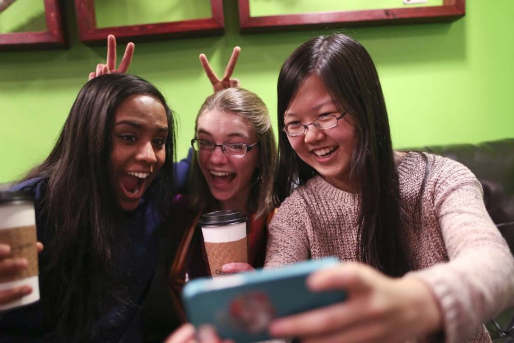 Friends Amrita Mohanty, 16, from left, Marta Williams, 16, and Michelle Mao, 15, take a Snapchat "selfie" while having coffee at the Steepery Tea Bar in Woodbury, Minn., Dec. 12, 2013. (Renee Jones Schneider/Minneapolis Star Tribune/MCT)