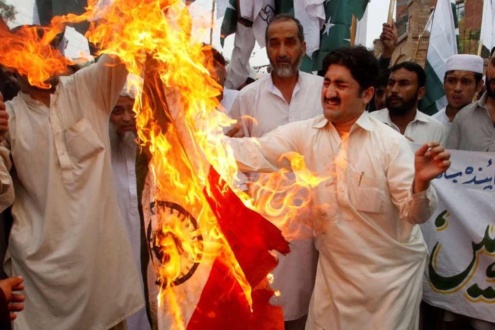 Protesters burn an Indian flag during a protest against the recent border clashes, in Peshawar, Pakistan. Photo: Reuters