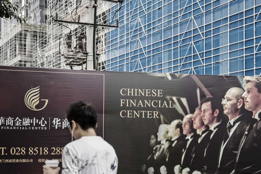 A pedestrian walks past an advertisement for the Chinese Financial Center in the central business district of Chengdu, China. Photo: Bloomberg