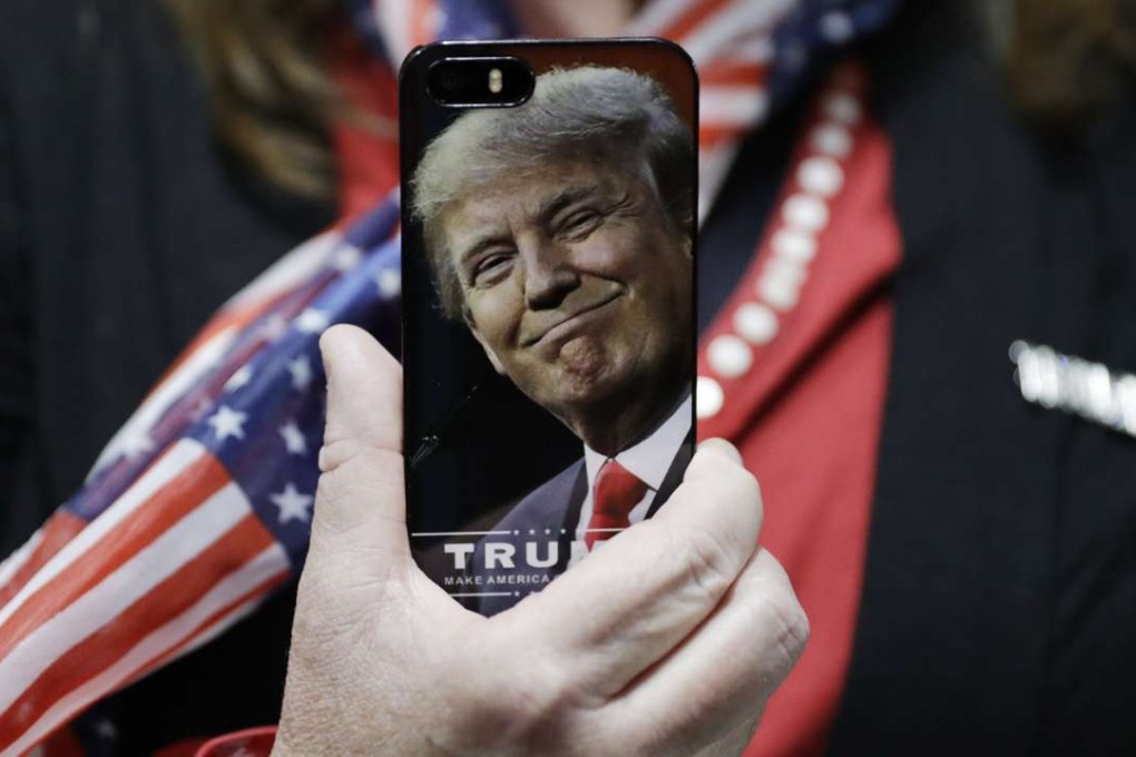A supporter of Donald Trump holds up her cellphone before a rally in Bedford, New Hampshire. Photo: AP