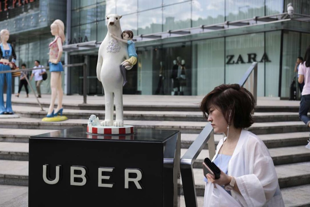 A woman walks past an Uber station outside a shopping mall in Beijing. Photo: AP