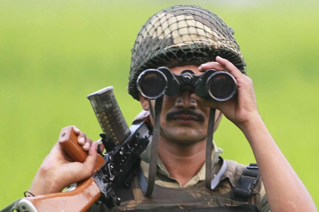 An Indian Border Security Force soldier uses binoculars to look at the Pakistan side of the border at Ranbir Singh Pura, about 35km from Jammu. Photo: AP
