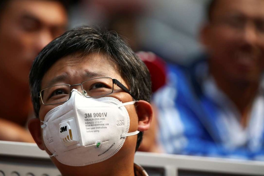 A spectator at an international tennis tournament in Beijing wears a mask to protect against pollution on Sunday. Photo: Reuters