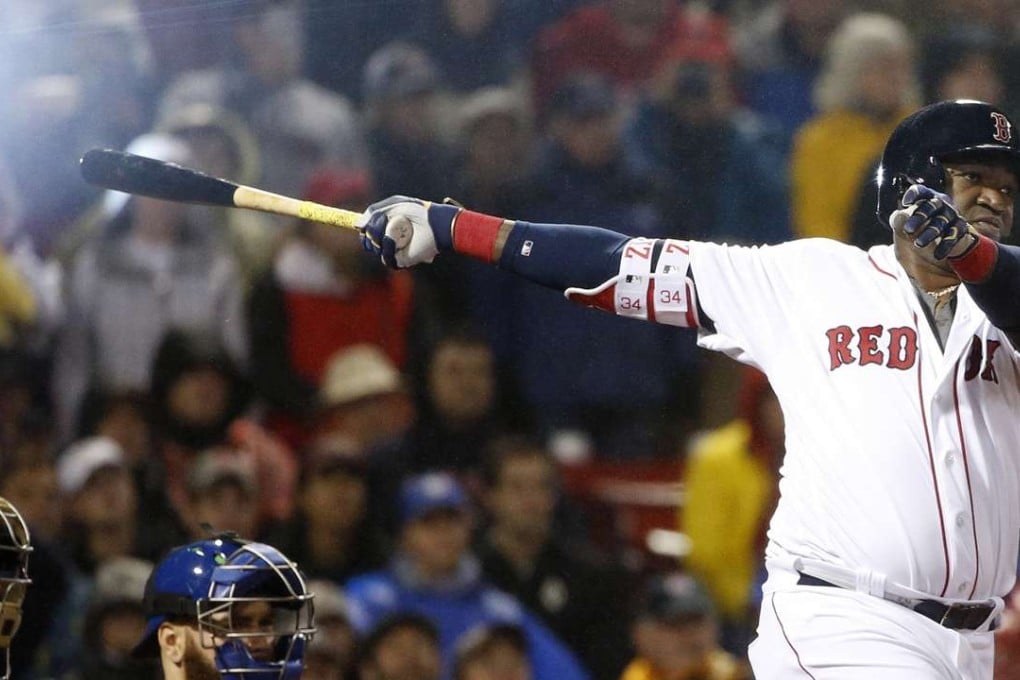 A camera flash goes off in the stands as Boston Red Sox's David Ortiz, right, follows through on a single in front of Toronto Blue Jays' Russell Martin during the fifth inning of a baseball game in Boston. Photo: AP