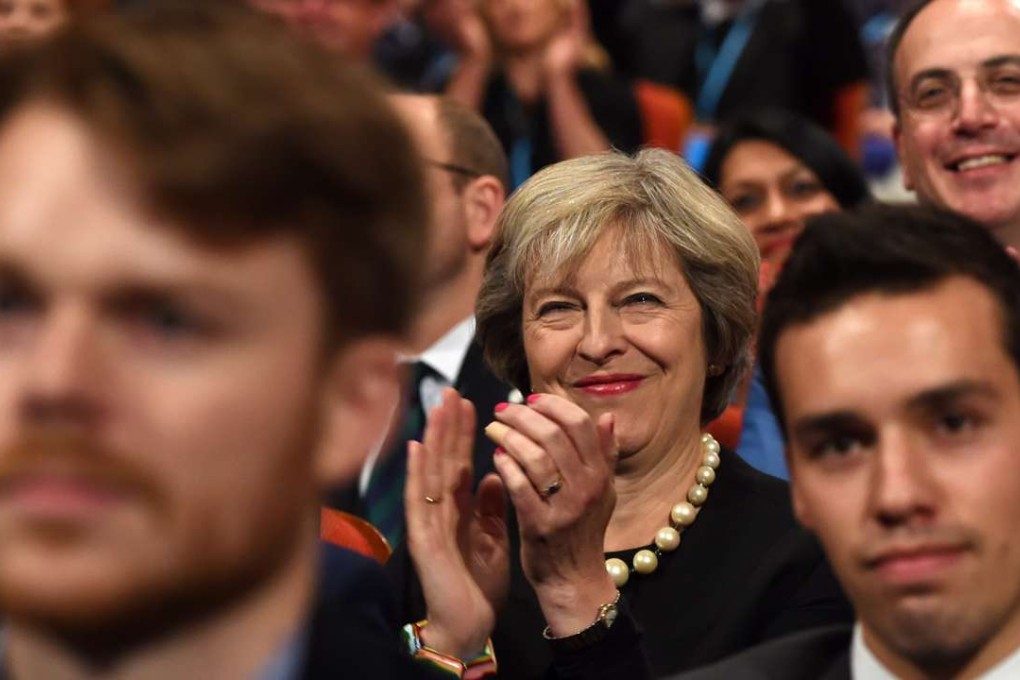 British Prime Minister Theresa May smiles as she listens to delegates during the Conservative Party conference in Birmingham. Photo: EPA