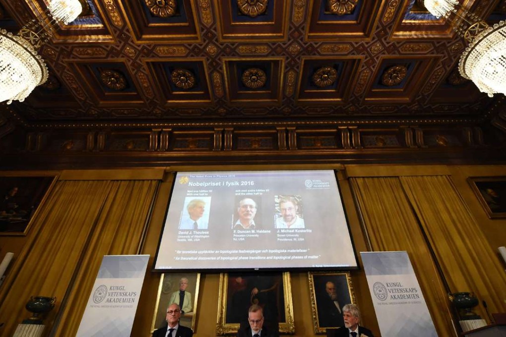 The acting chairman of the Nobel Committee for Physics Nils Martensson, the Permanent Secretary of the Royal Swedish Academy of Sciences Goran K Hansson and Thors Hans Hansson, member of the Nobel Committee for Physics sit in front of a screen displaying the winners. Photo: AFP