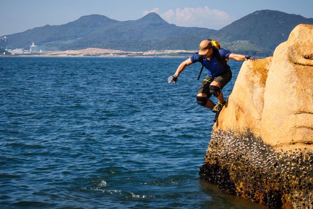 Hong Kong-based climber, adventurer and motivational speaker Paul Niel jumps off a granite rock into the water on the Shek O headland while coasteering. Photo: Tessa Chan