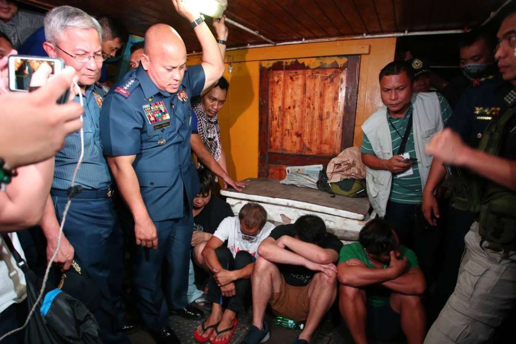 Four arrested Hong Kong men bow their heads as police chief Ronald Dela Rosa looks on during an inspection of an alleged floating drugs laboratory. Photo: SCMP Pictures