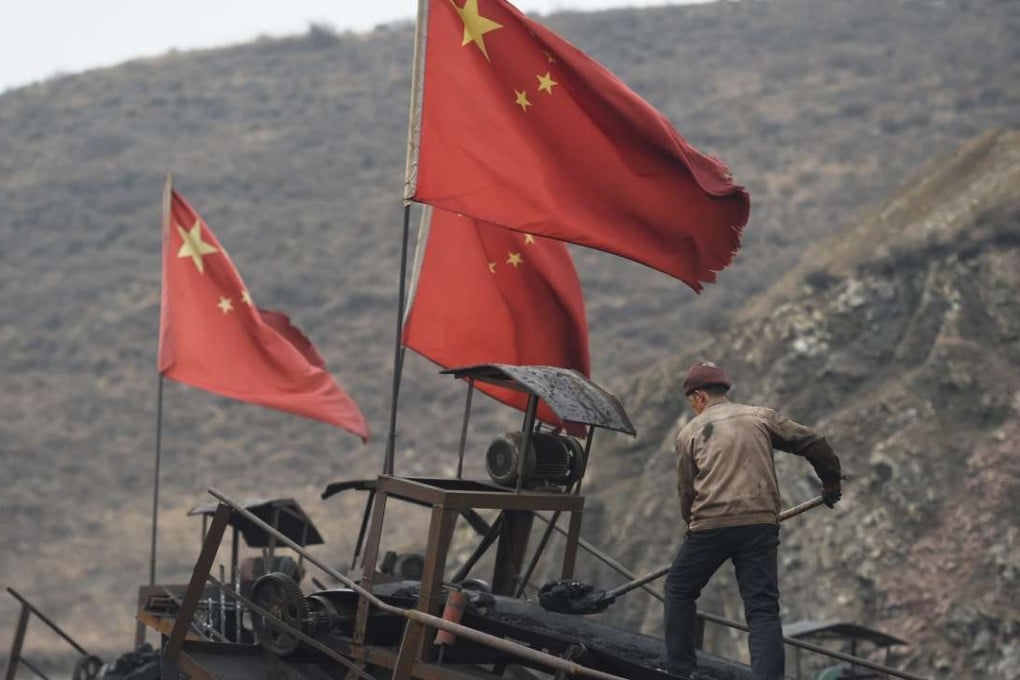 A worker clears a conveyer belt used to transport coal, near a coal mine at Datong, in China's northern Shanxi province. Photo: AFP