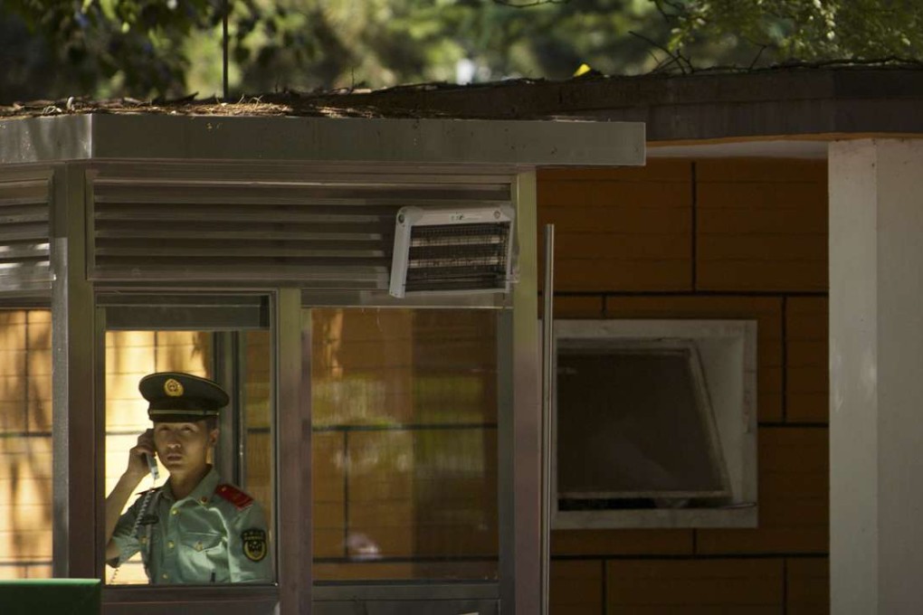 A Chinese paramilitary policeman talks on the telephone at a guard booth outside the North Korean embassy in Beijing. File photo: AP